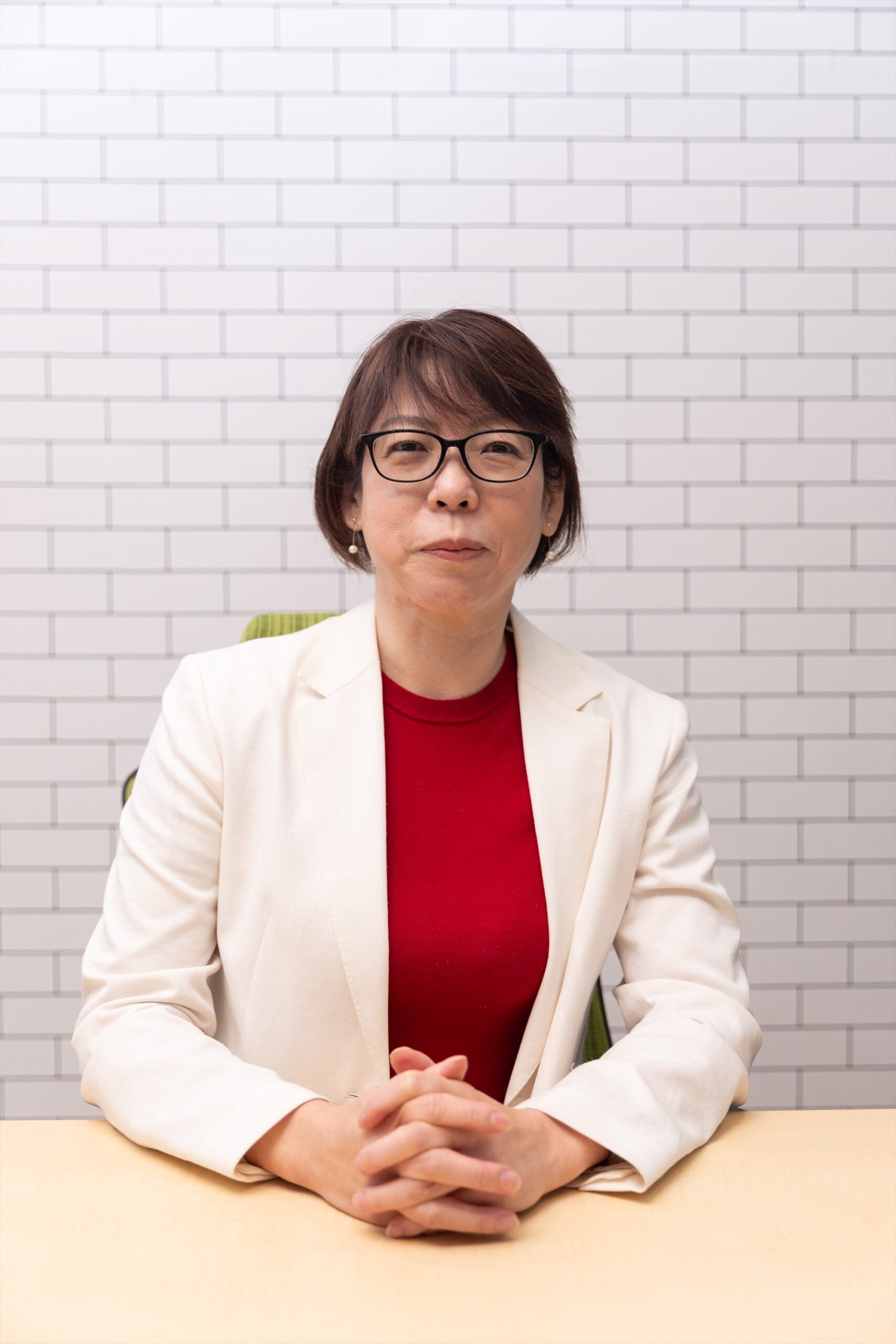 白スーツに赤インナーを着た女性の写真（丸山ひろみ）