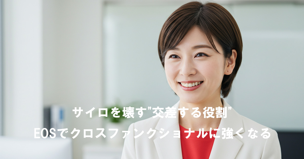 白いジャケットに赤いインナーを着た女性リーダーが笑顔で前を見つめている。サイロを壊し、交差する役割を担うクロスファンクショナルな強さをイメージした写真。