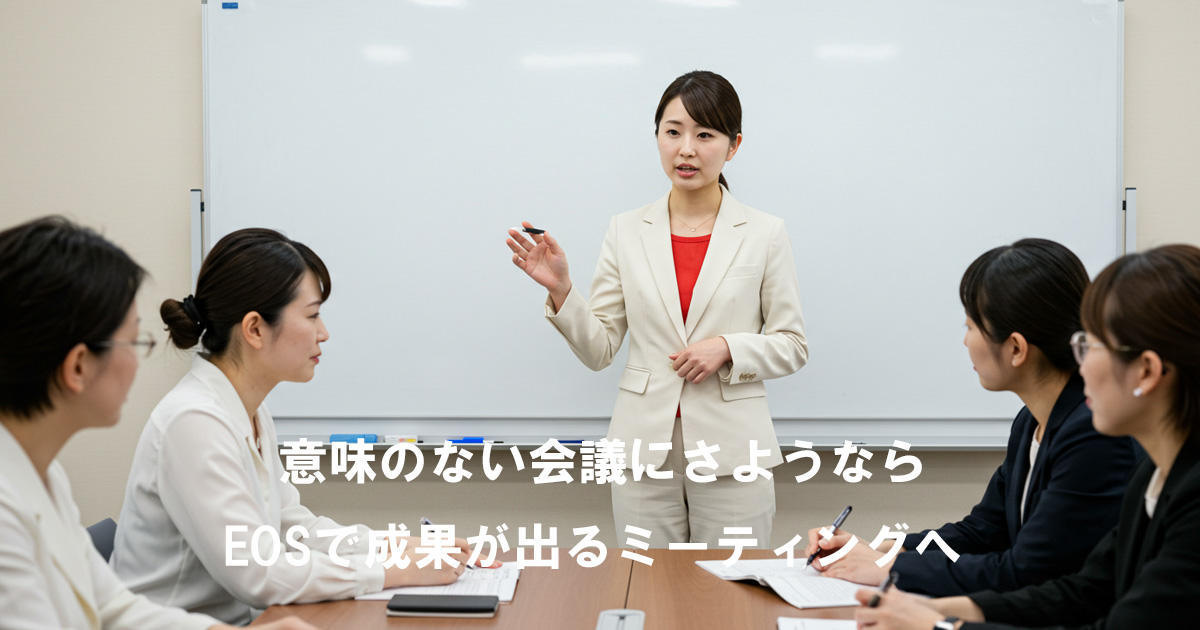 ホワイトボード前で女性リーダーが話す様子。会議に参加する女性たちが真剣に耳を傾けている。EOSによる成果の出るミーティングを表現