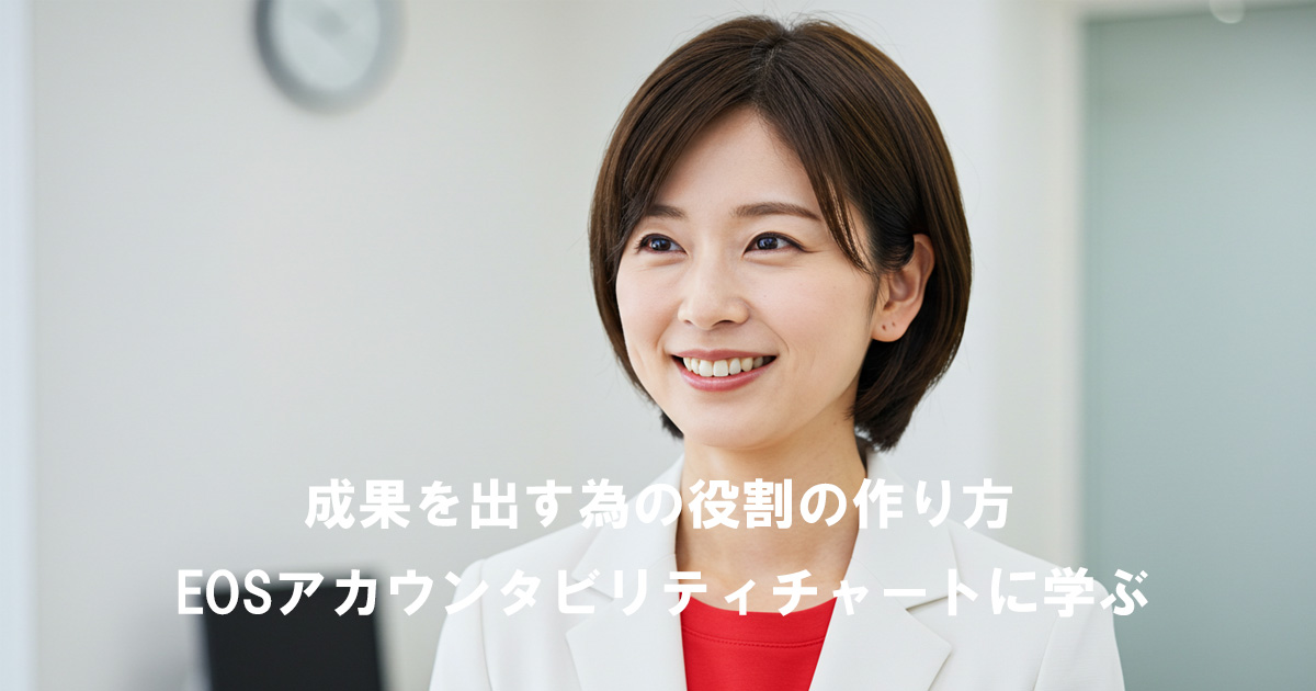 白いジャケットに赤いインナーを着た女性リーダーが笑顔で話している。記事タイトル『成果を出す為の役割の作り方｜EOSアカウンタビリティチャートに学ぶ』のアイキャッチ画像