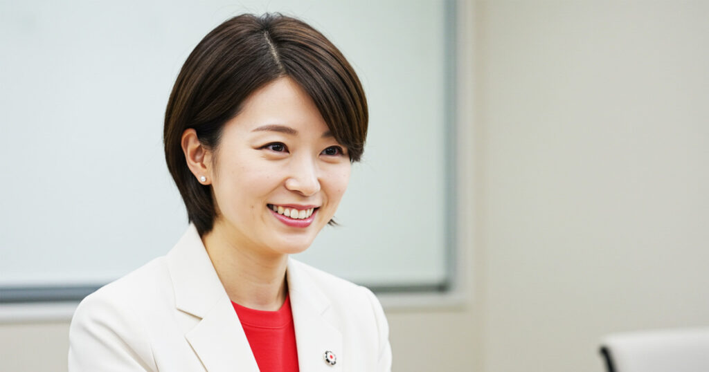 笑顔で会話する女性リーダー。同じ言語を使うことで組織の認識ズレを防ぎ、文化を統一するイメージ