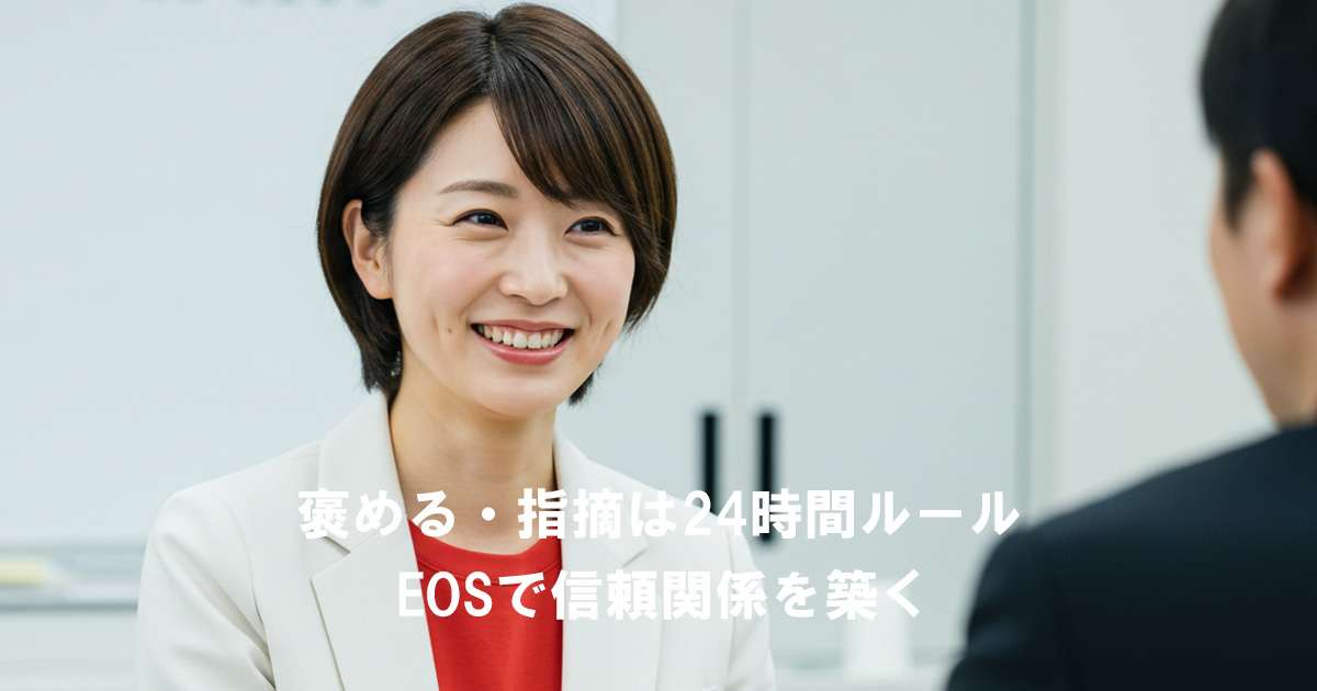 笑顔で部下と向き合う女性リーダー。EOSの24時間ルールを実践し、称賛や指摘を即時に伝えて信頼関係を築いている場面。